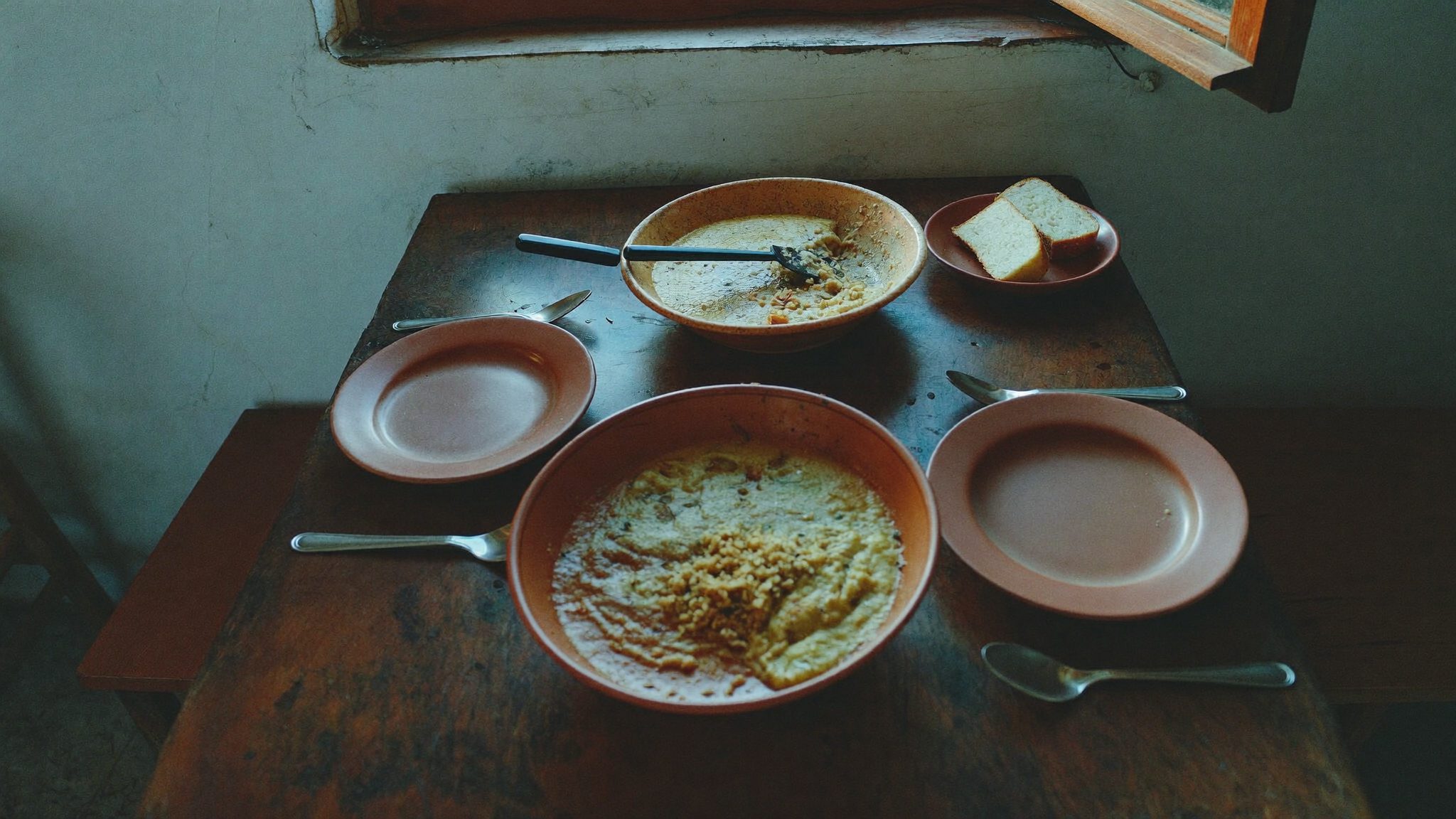 Mesa posta junto à janela, com luz suave, num restaurante no Centro Histórico de Évora