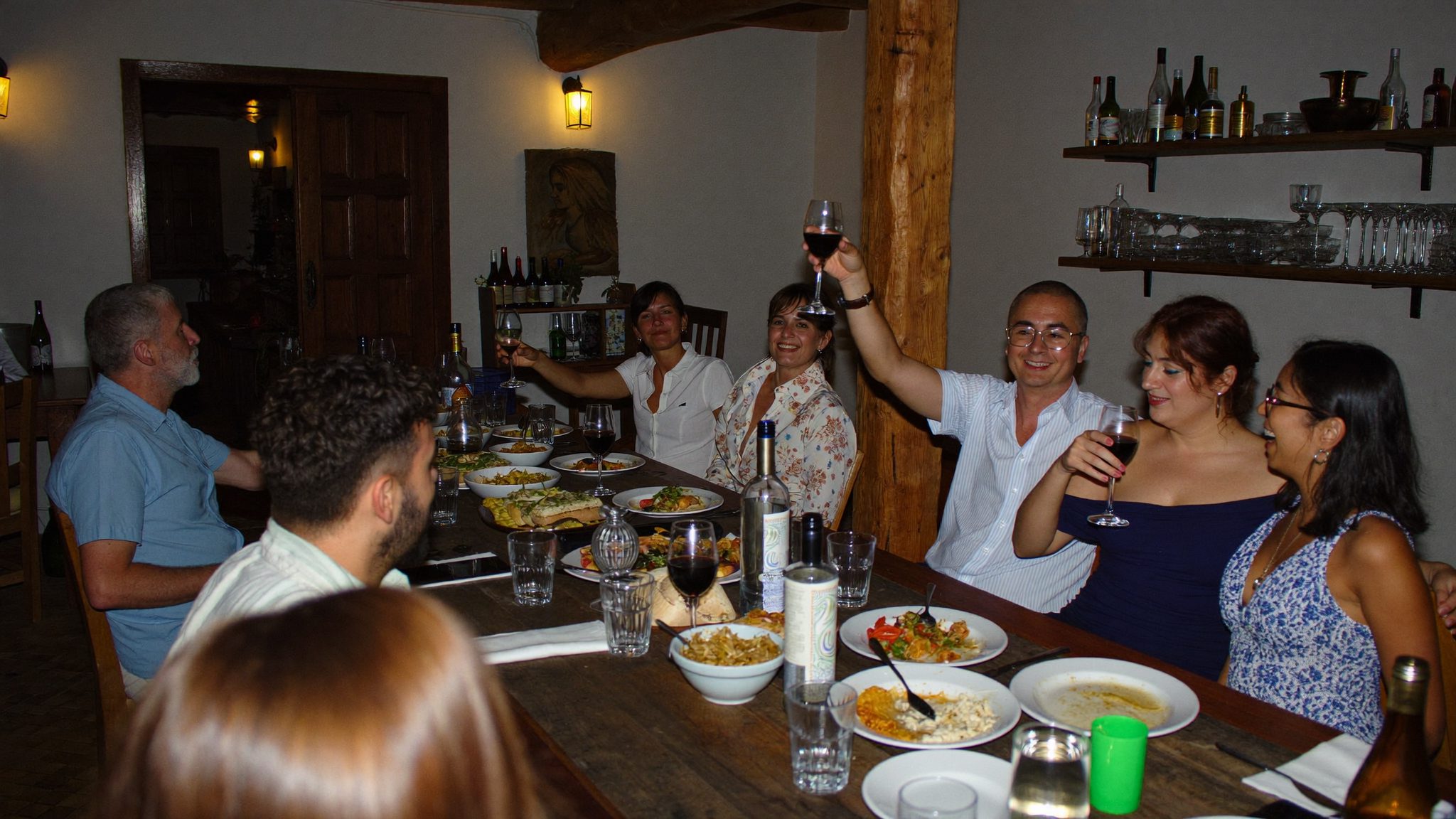 Grupo de amigos à volta de uma mesa comprida num almoço na Casa Fengenlia