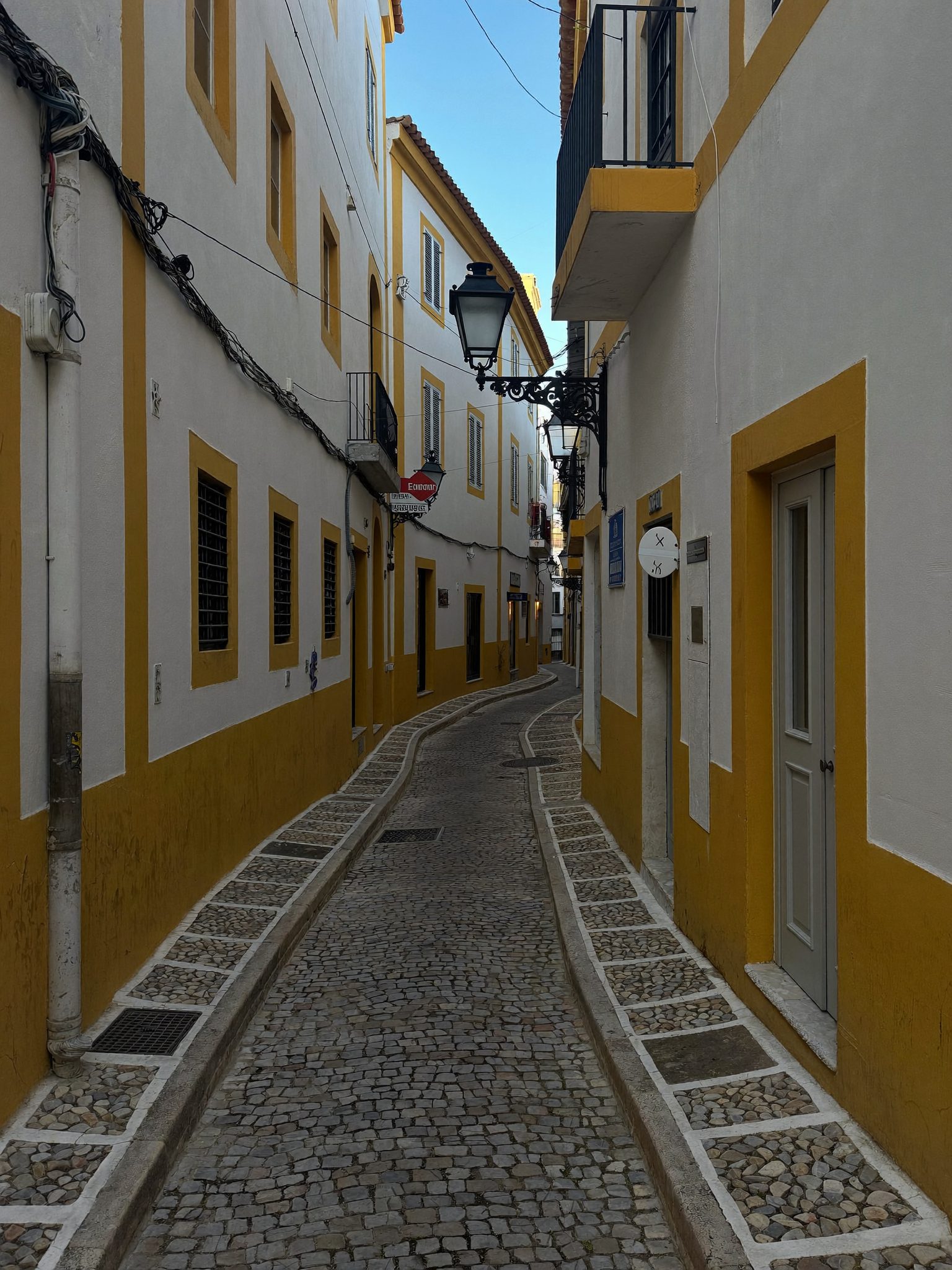 Rua caiada de branco no Centro Histórico de Évora, perto da Casa Fengenlia